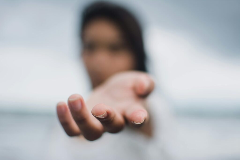 A soft focus image highlighting a reaching hand, symbolizing connection or help.